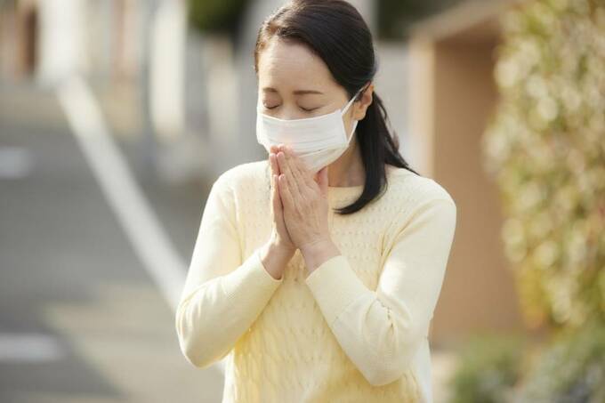 手を合わせるマスクをした女性