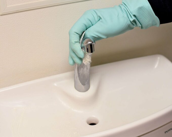 蛇口回りをクレンザーとラップで磨く様子
