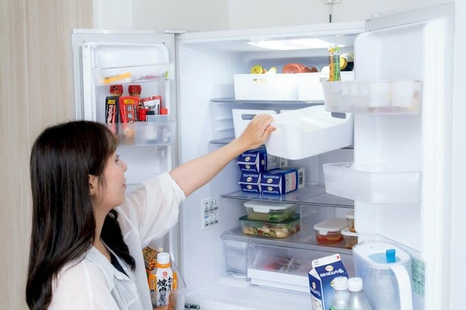 冷蔵庫の中を収納ケースで整理整頓している様子