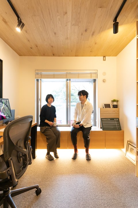 窓際の収納ベンチでくつろぐ夫妻