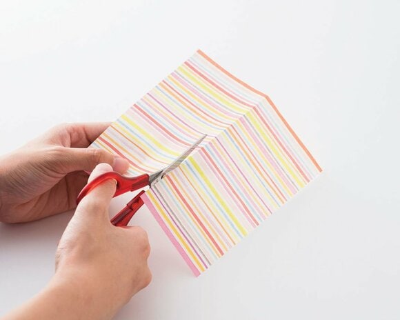 折り紙をハサミで半分に切る。