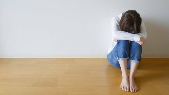 ひざを抱える女性