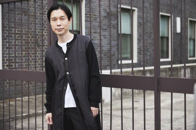 塀のままにたたずむ男性