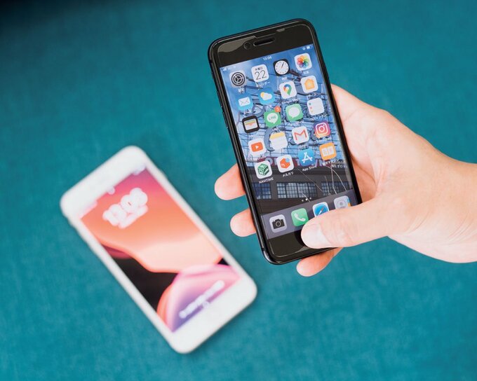 床のスマホとスマホを持つ手