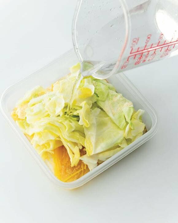 耐熱容器に入っている乾麺とキャベツに水を入れる