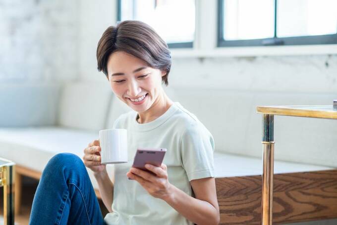 コップを持ちながらスマホを操作する様子