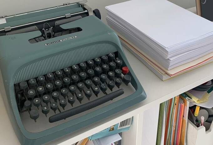 白い棚の上にタイプライターを置いた様子