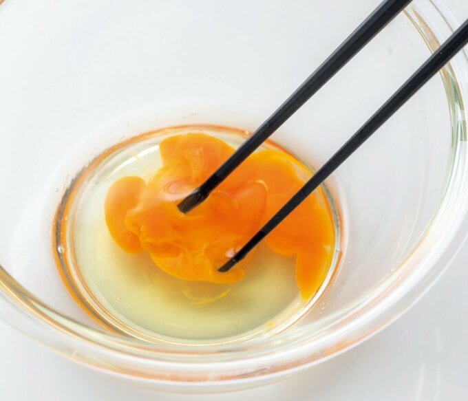 ボウルに入れた卵を混ぜている写真