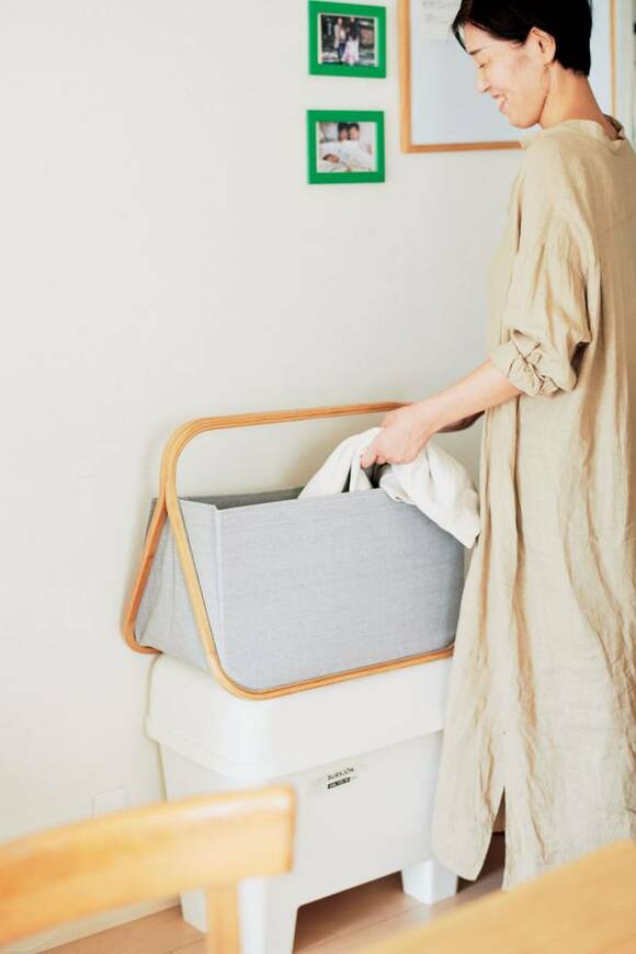 カゴに衣類を入れる女性