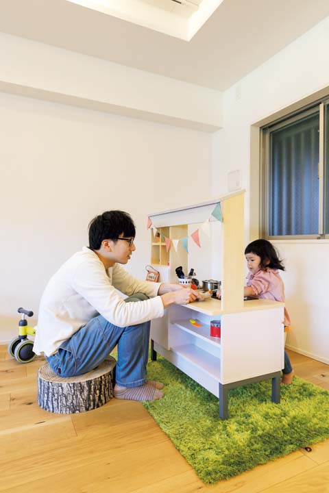 キッズキッチンで遊ぶ父と娘