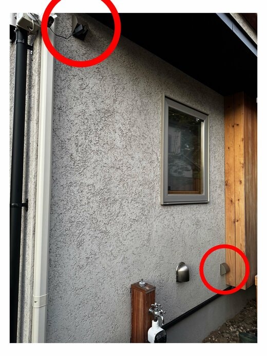 家の外壁。左の高い位置にコンセントがあり、監視カメラがつながっている。右下にもコンセントがある。その左に屋外水栓がある。