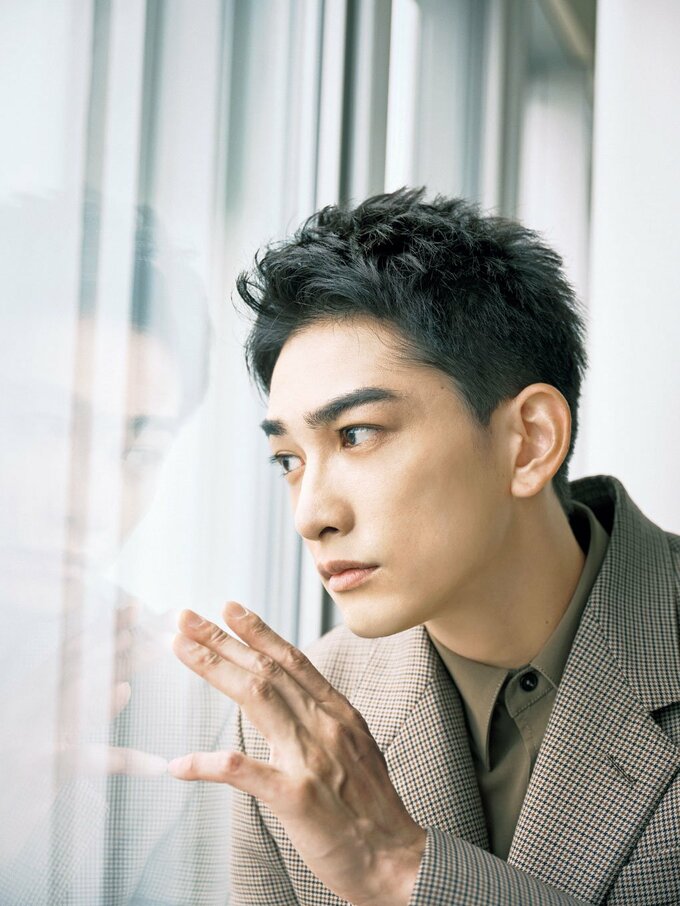 窓際窓の外を見る男性