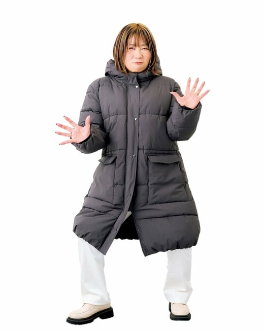 ダウンジャケットを着て関取のポーズをする女性