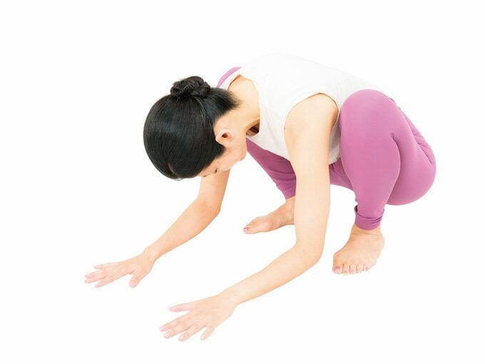腰を丸めて床に両手をつく