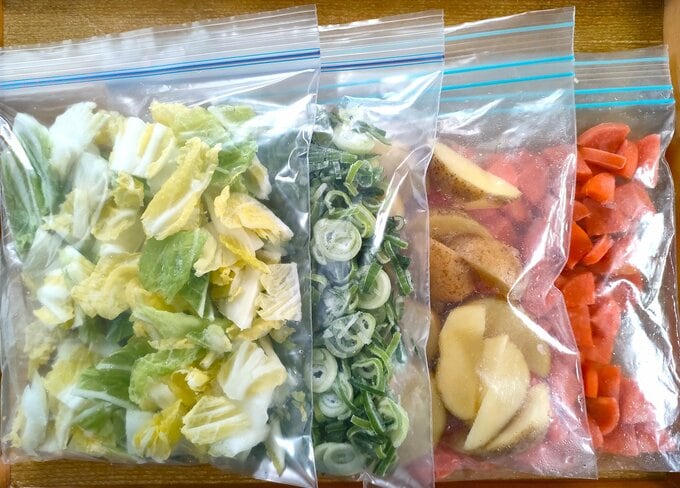 チャックつきポリ袋に入れたカット野菜。左から白菜、長ネギ、ジャガイモ、ニンジン