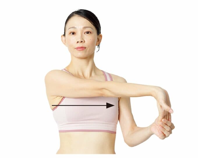 右腕を伸ばすストレッチをしている女性