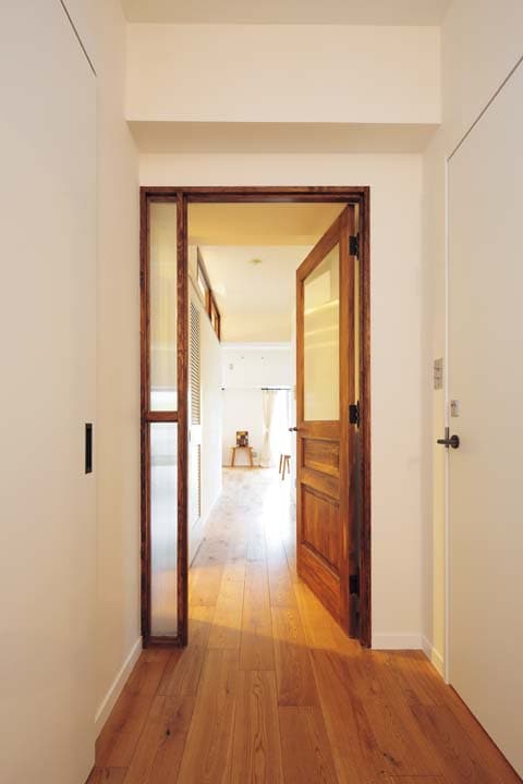 親子ドア風に仕上げたリビングダイニングの出入り口の木製ドア