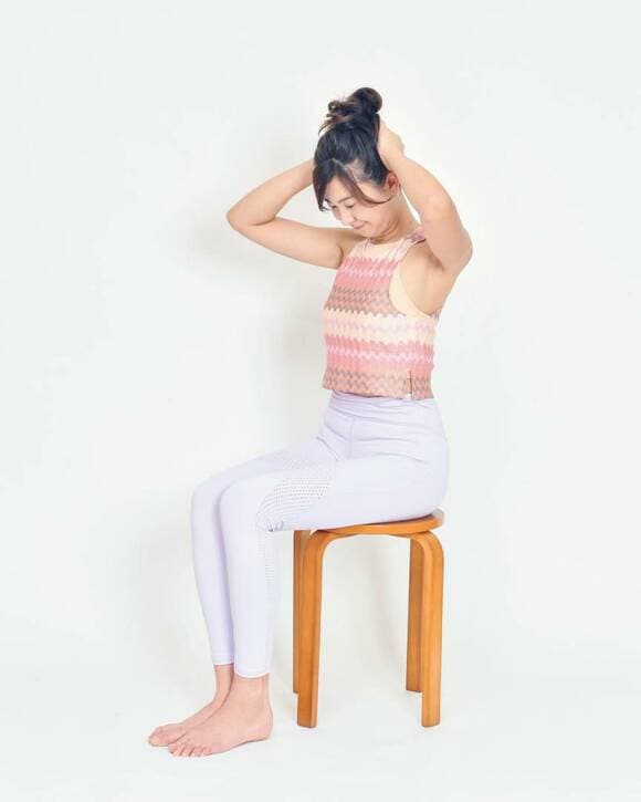 手を頭の後ろに当てる女性