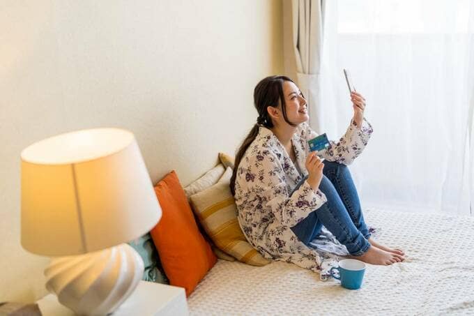 カードとスマホを持つ女性