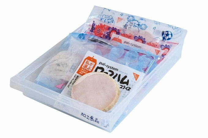 半透明の白色トレイに並ぶハムなどの食品