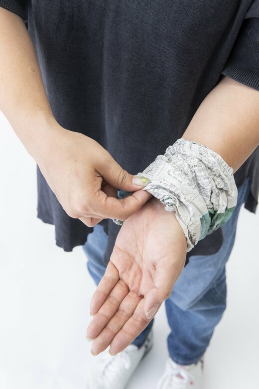 新聞紙を腕に巻く様子