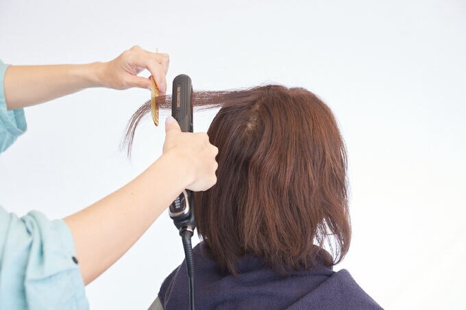 ヘアアイロンと女性