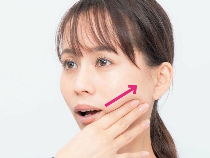 アゴに手を当てる女性