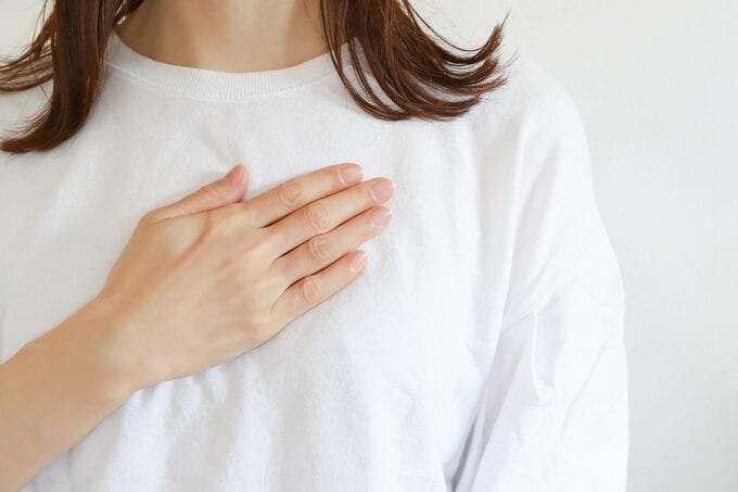 胸に手を当てる女性