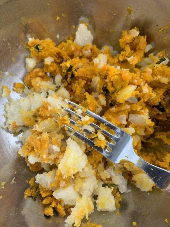 ジャガイモとカボチャをボウルにいれてフォークの背を使って潰す