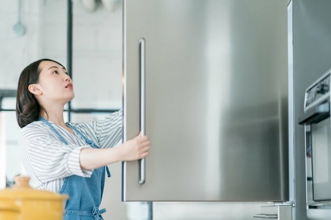 冷蔵庫を見る女性