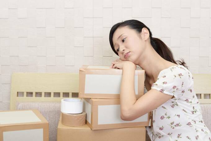 箱の上で悩む女性