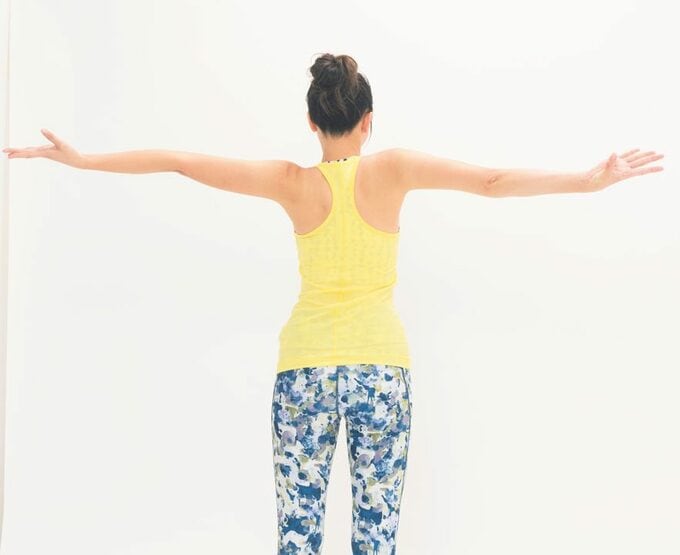 黄色女性両手広げる後ろ姿