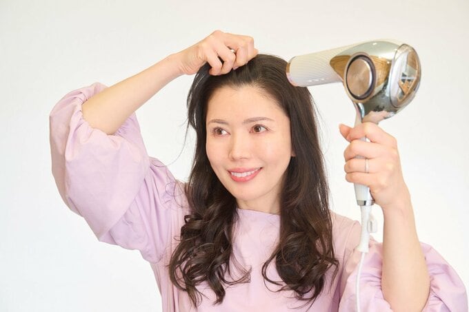 ドライヤーをする女性