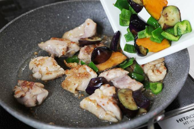 お肉が入ったフライパンに野菜を投入