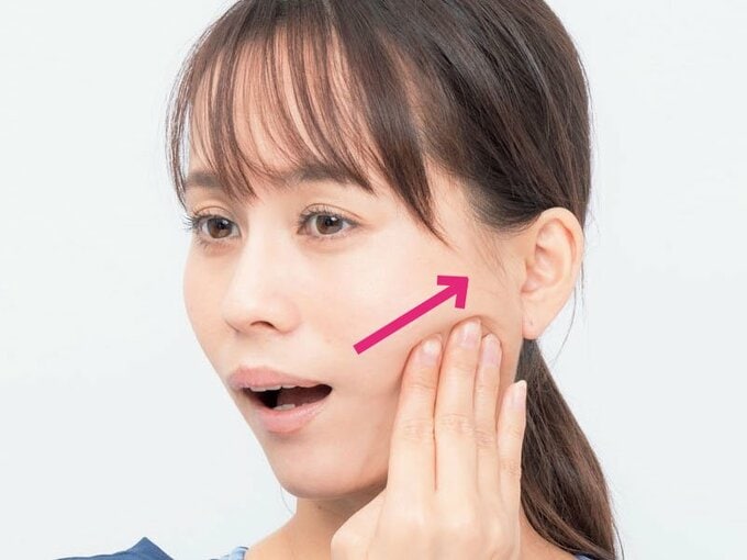 頬に手を当てる女性