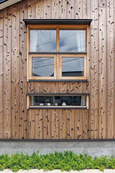 焼杉の外壁に木製サッシ、妻の作品を飾るフィックス窓