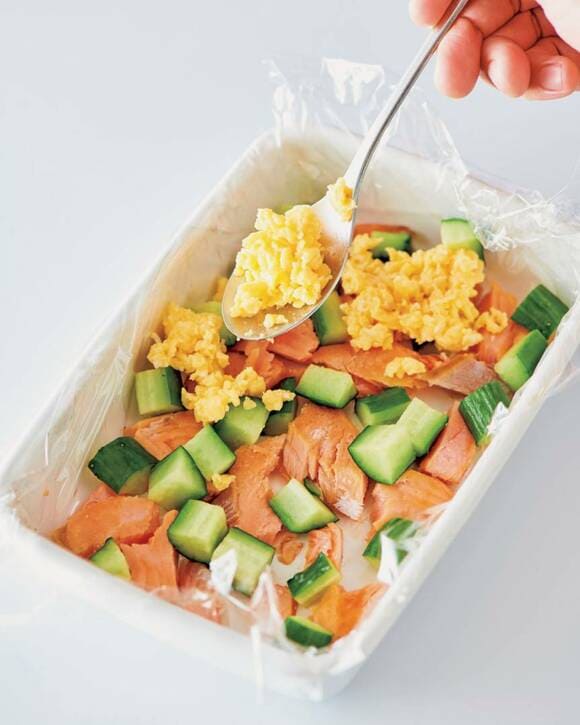 キュウリとサーモンの上に卵を入れる