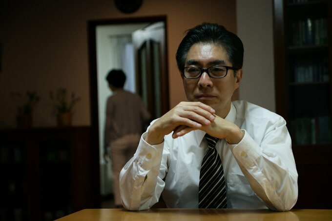 暗がりに座る男性