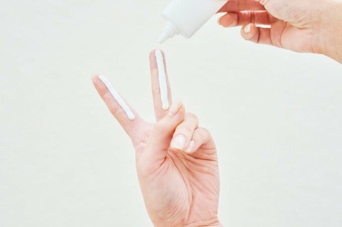 ピースをして人差し指と中指にたっぷりと日焼け止めを塗布