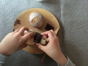パキパキっと割った板チョコをはさみます。パンが温かいうちにはさむことが大切です