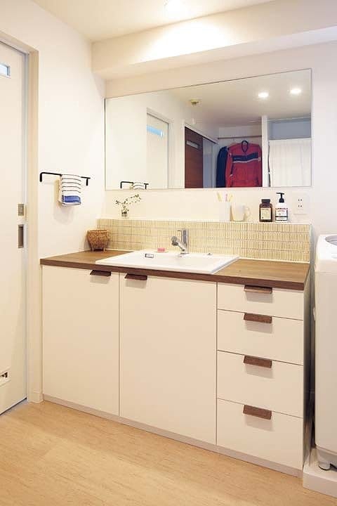 ぬくもりのある取手とレトロなタイルをさりげなく取り入れた家具のような洗面台