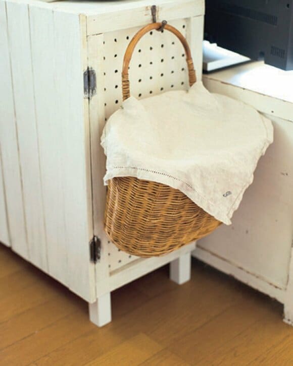 テレビ台のサイドにフックをつけて引っかけたカゴ