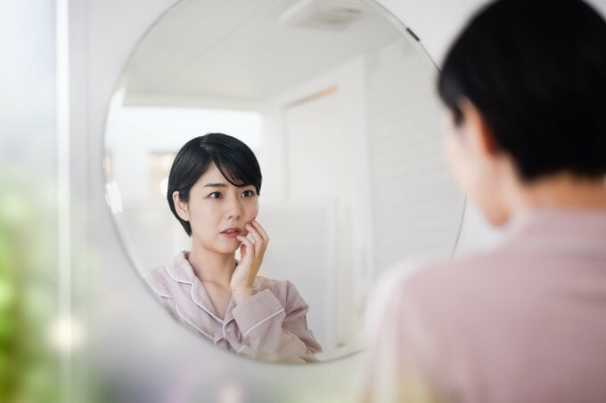 頬をおさえる女性