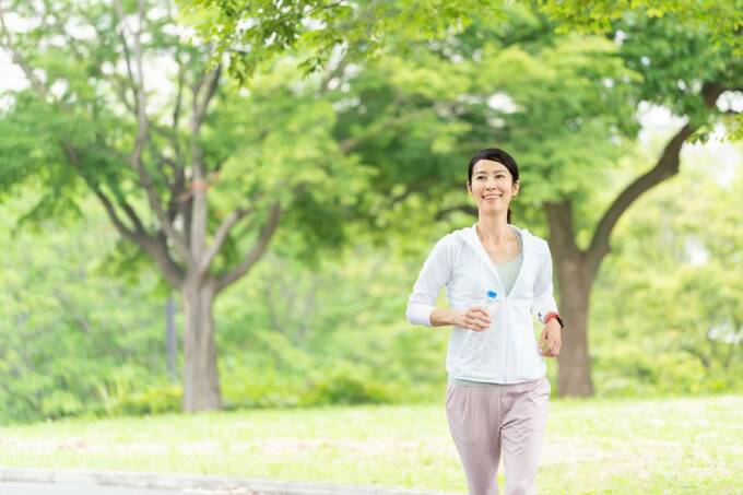 ペットボトルを持って走る女性