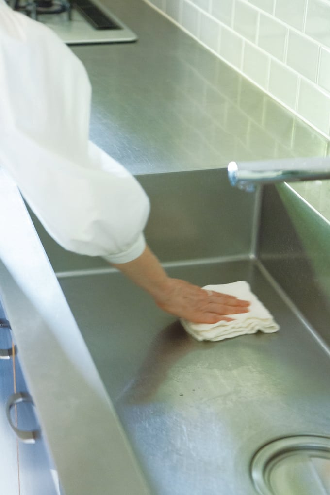 シンクをふいている引田さんの腕