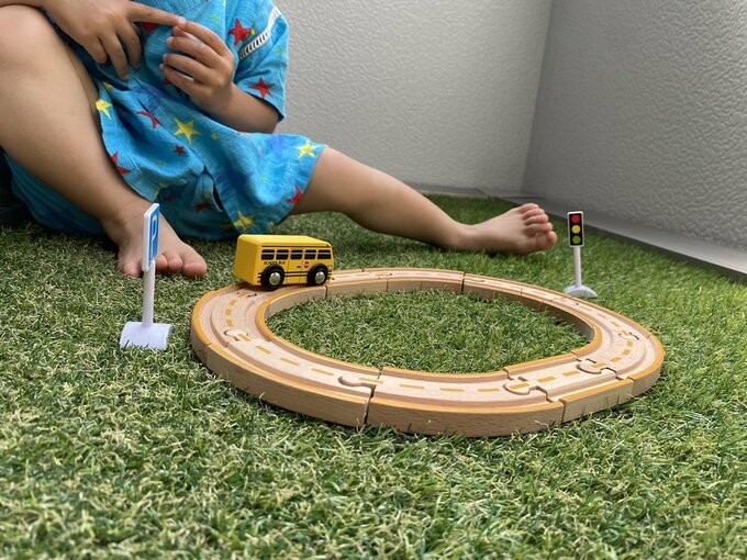 人工芝でオモチャを持ってきて遊ぶ子ども