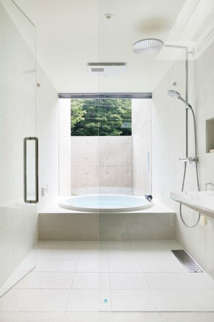 床から天井まで白いタイルが貼られた浴室