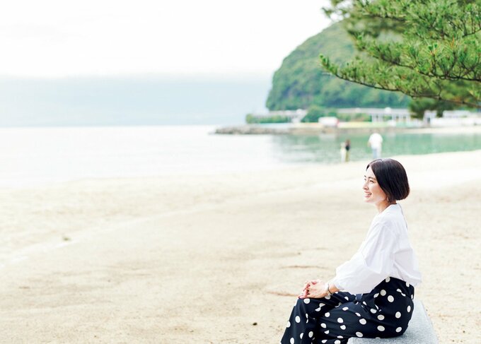 浜辺で腰掛け海を眺める女性