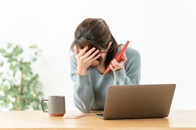 電卓をもって苦しむ女性