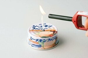 こよりの先まで油がしみ込んだら、点火棒で火をつける。